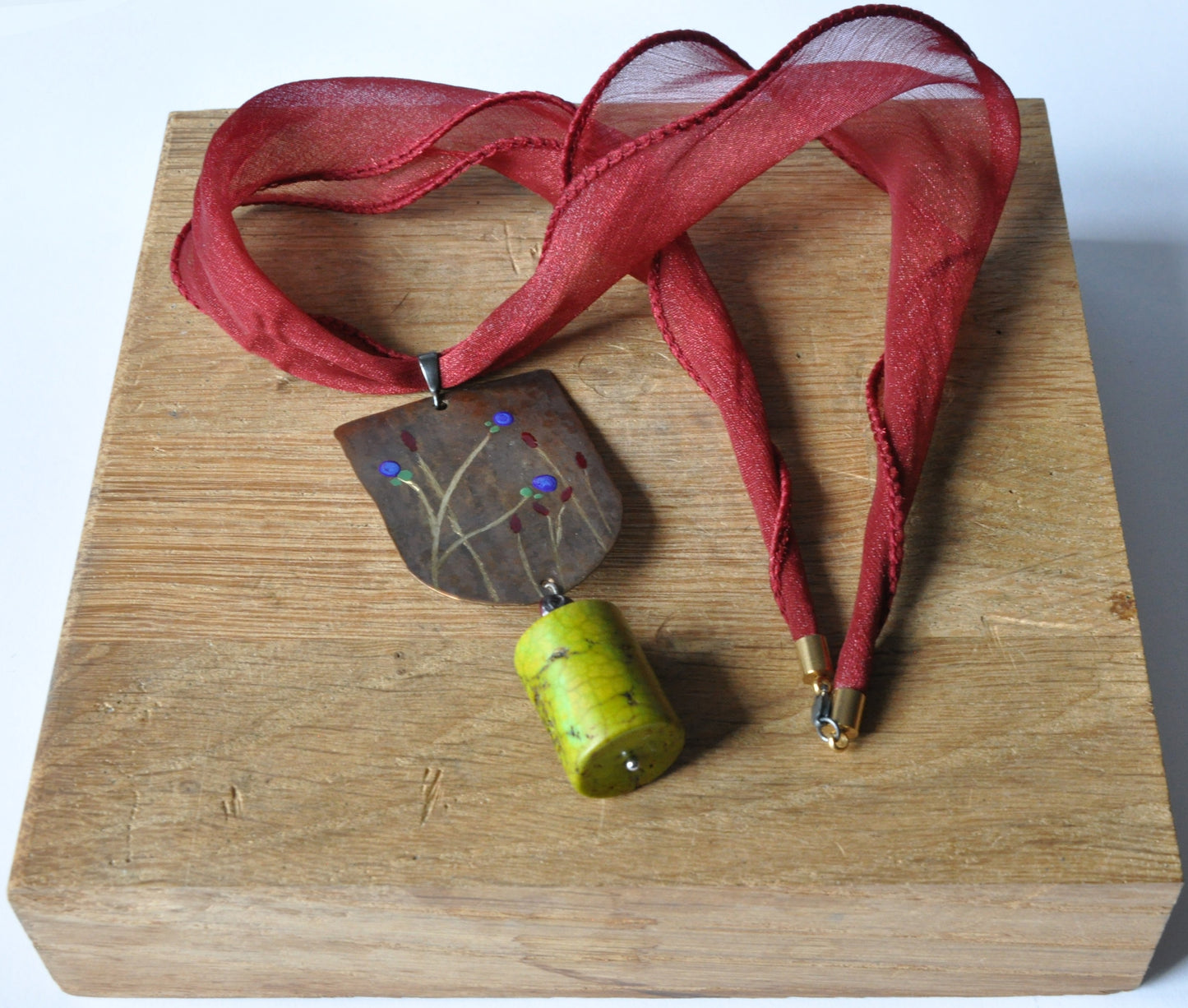 Necklace with engraved and enameled brass and silver pendant with howlite cylinder 'Green Apple'