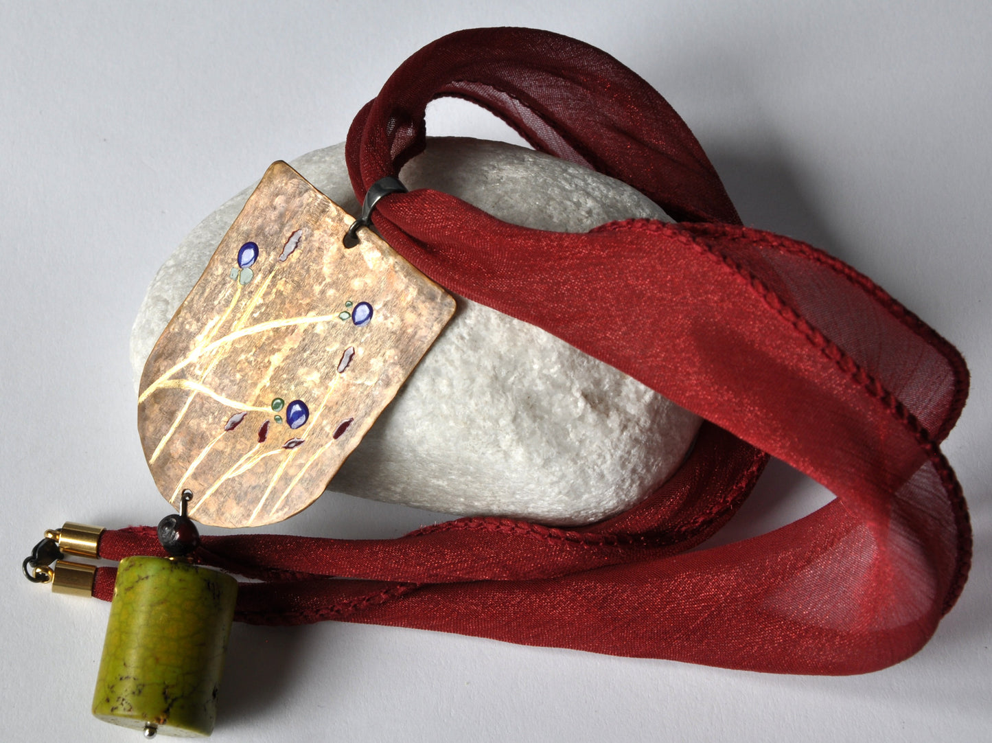 Necklace with engraved and enameled brass and silver pendant with howlite cylinder 'Green Apple'