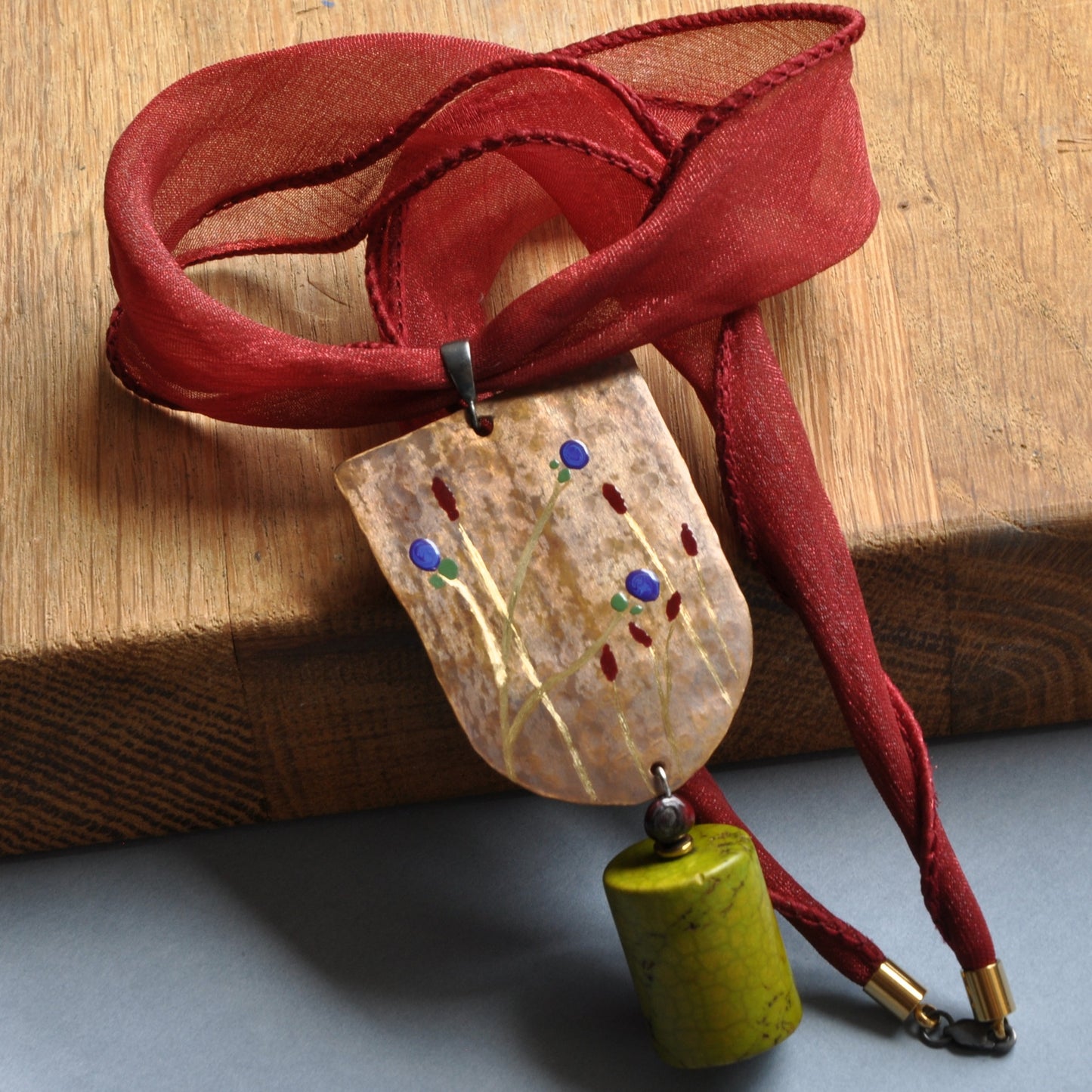 Necklace with engraved and enameled brass and silver pendant with howlite cylinder 'Green Apple'