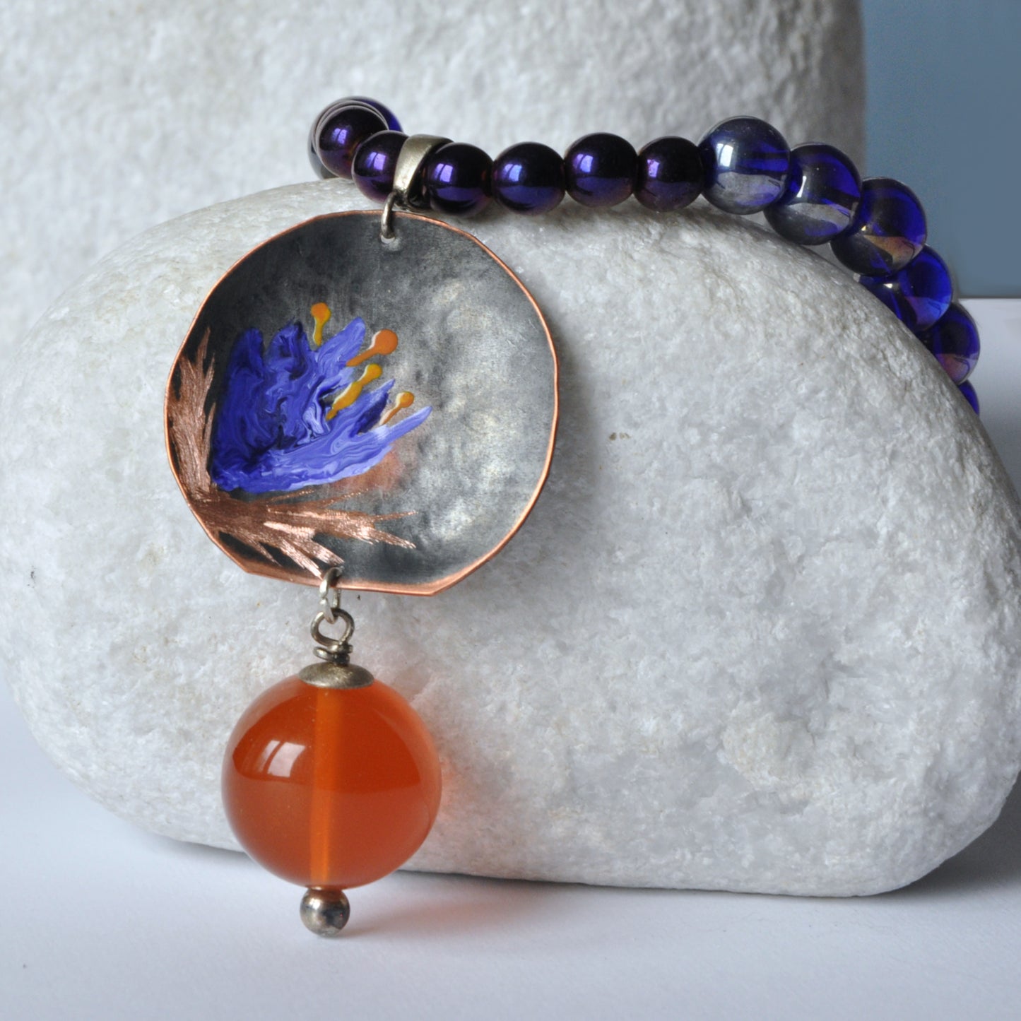 Necklace with patinated hand-forged & engraved copper pendant with enameled flower and orange resin smooth ball 'Dark Blue Lily'
