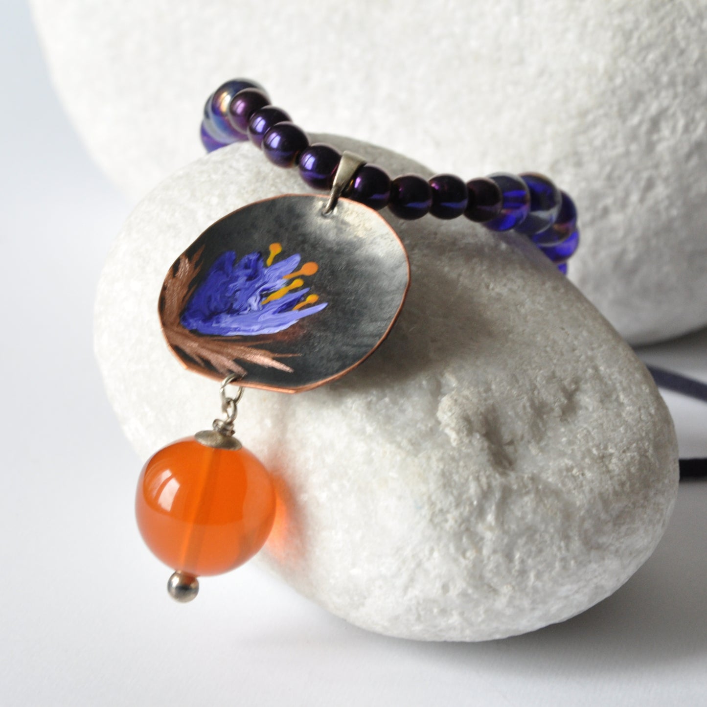 Necklace with patinated hand-forged & engraved copper pendant with enameled flower and orange resin smooth ball 'Dark Blue Lily'