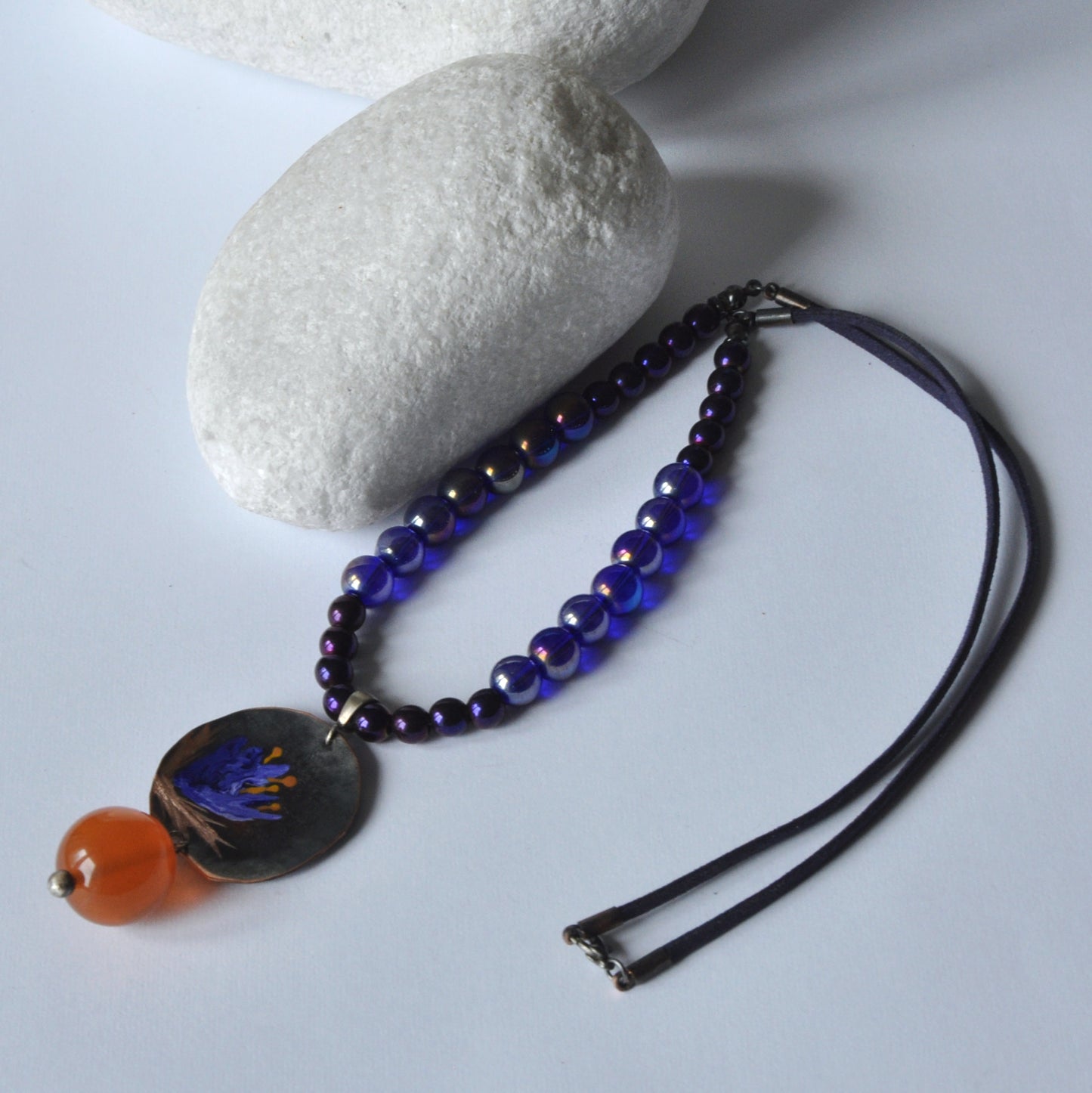 Necklace with patinated hand-forged & engraved copper pendant with enameled flower and orange resin smooth ball 'Dark Blue Lily'