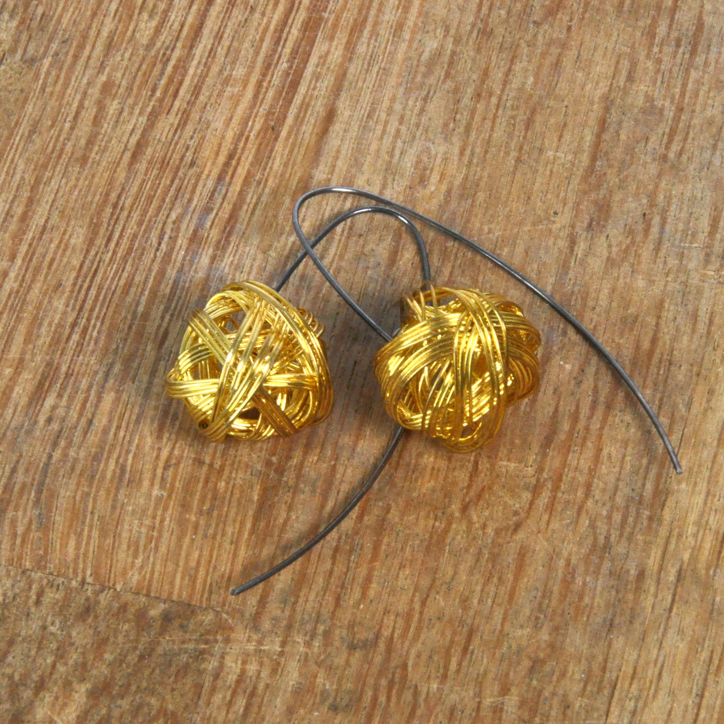 Geometric dangling earrings of brass and silver 'Golden Motes'