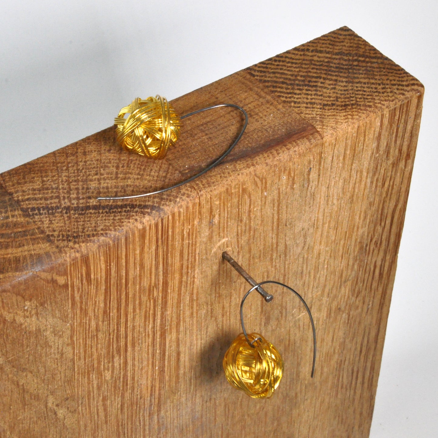 Geometric dangling earrings of brass and silver 'Golden Motes'