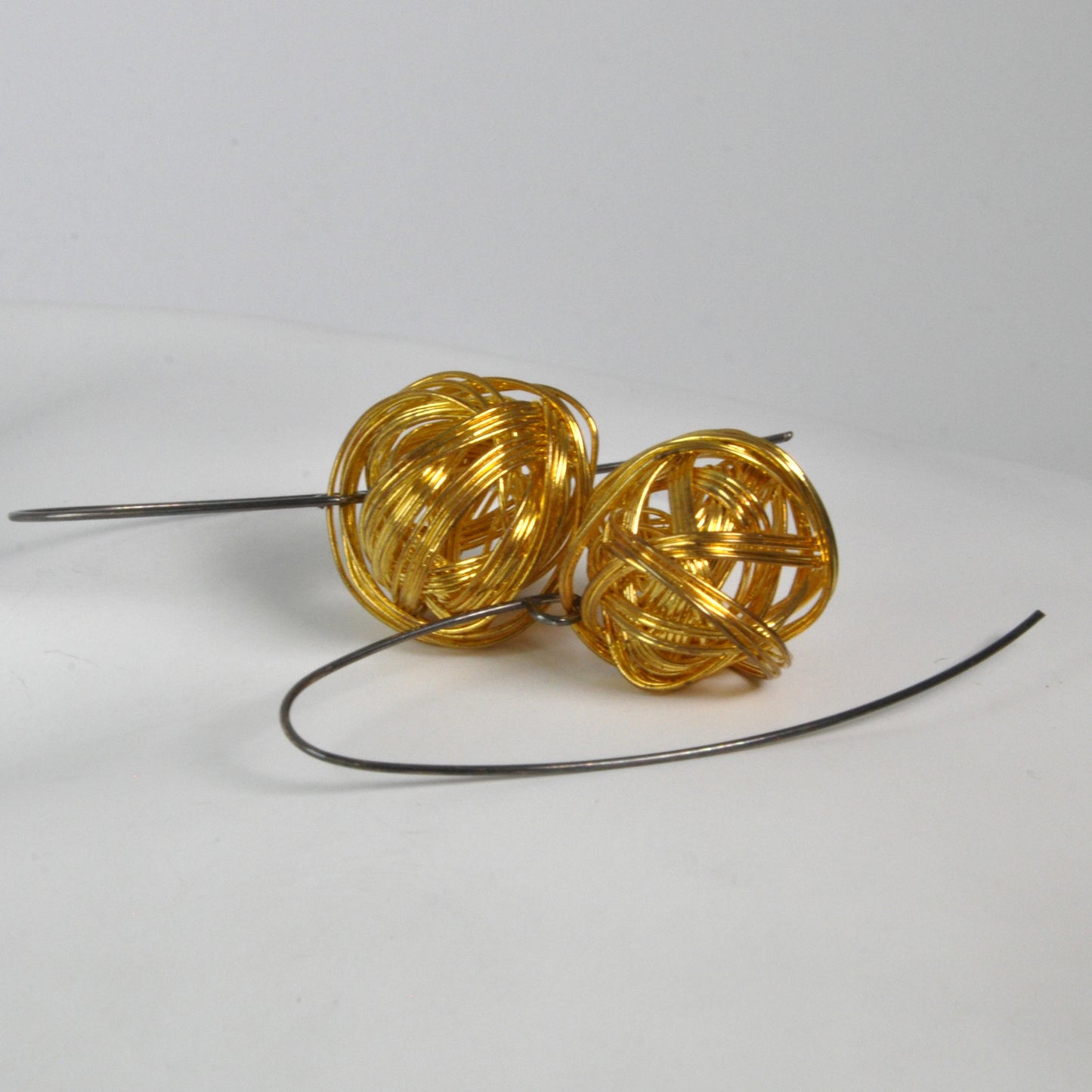 Geometric dangling earrings of brass and silver 'Golden Motes'