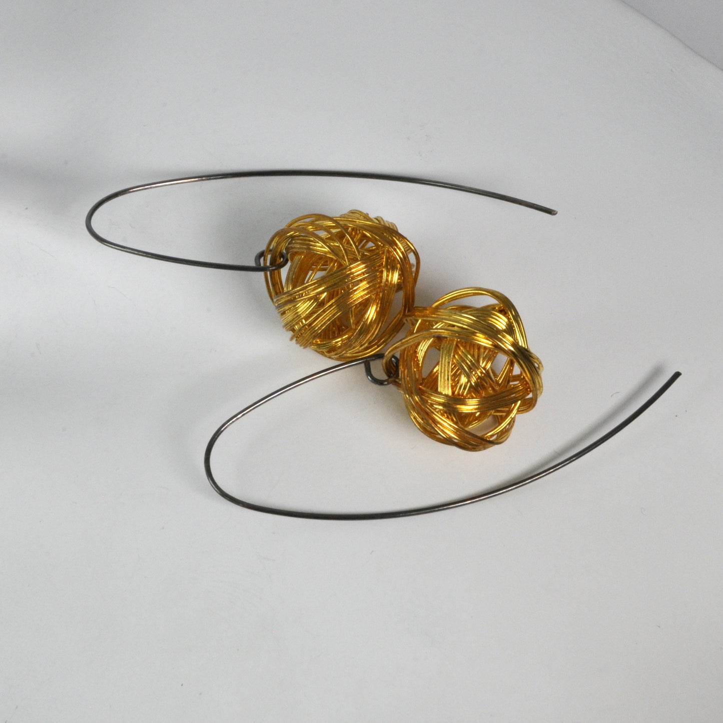 Geometric dangling earrings of brass and silver 'Golden Motes'