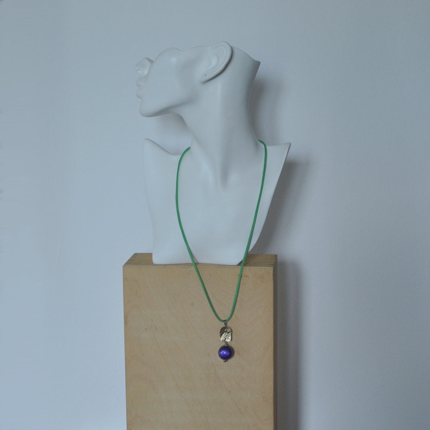 Necklace with patinated brass and engraved pendant and resin ball 'In Green Flowers and Purple'