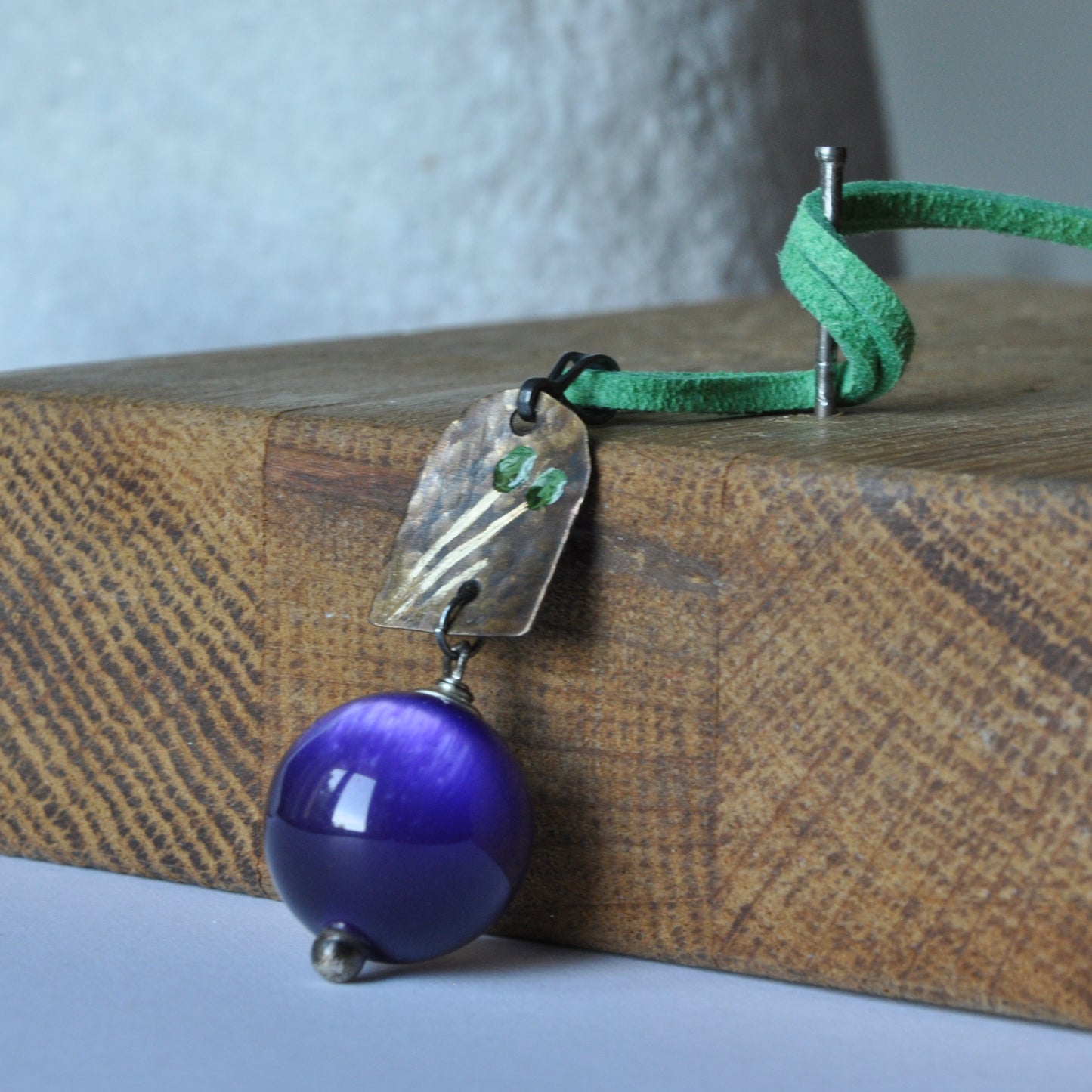 Necklace with patinated brass and engraved pendant and resin ball 'In Green Flowers and Purple'