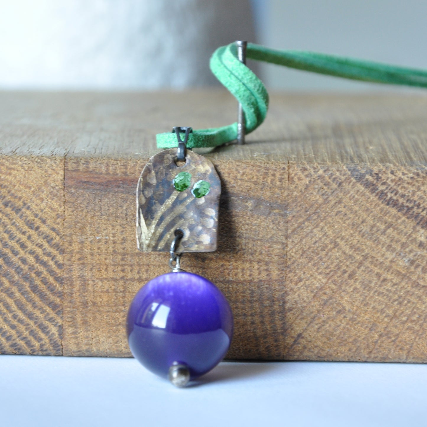 Necklace with patinated brass and engraved pendant and resin ball 'In Green Flowers and Purple'