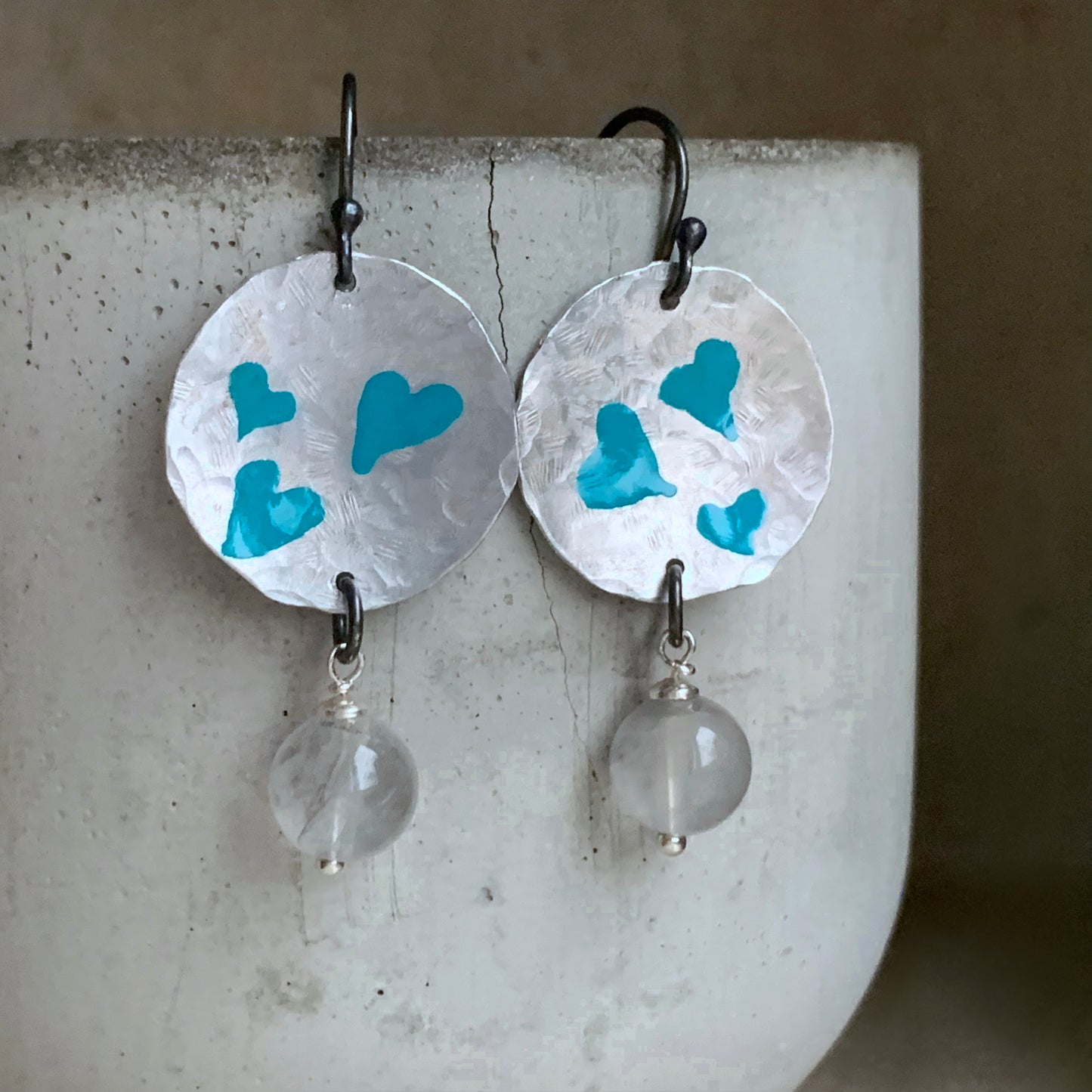 Hand forged aluminium enameled earrings in the shape of irregular circles and with hanging quartz 'Turquoise Hearts'