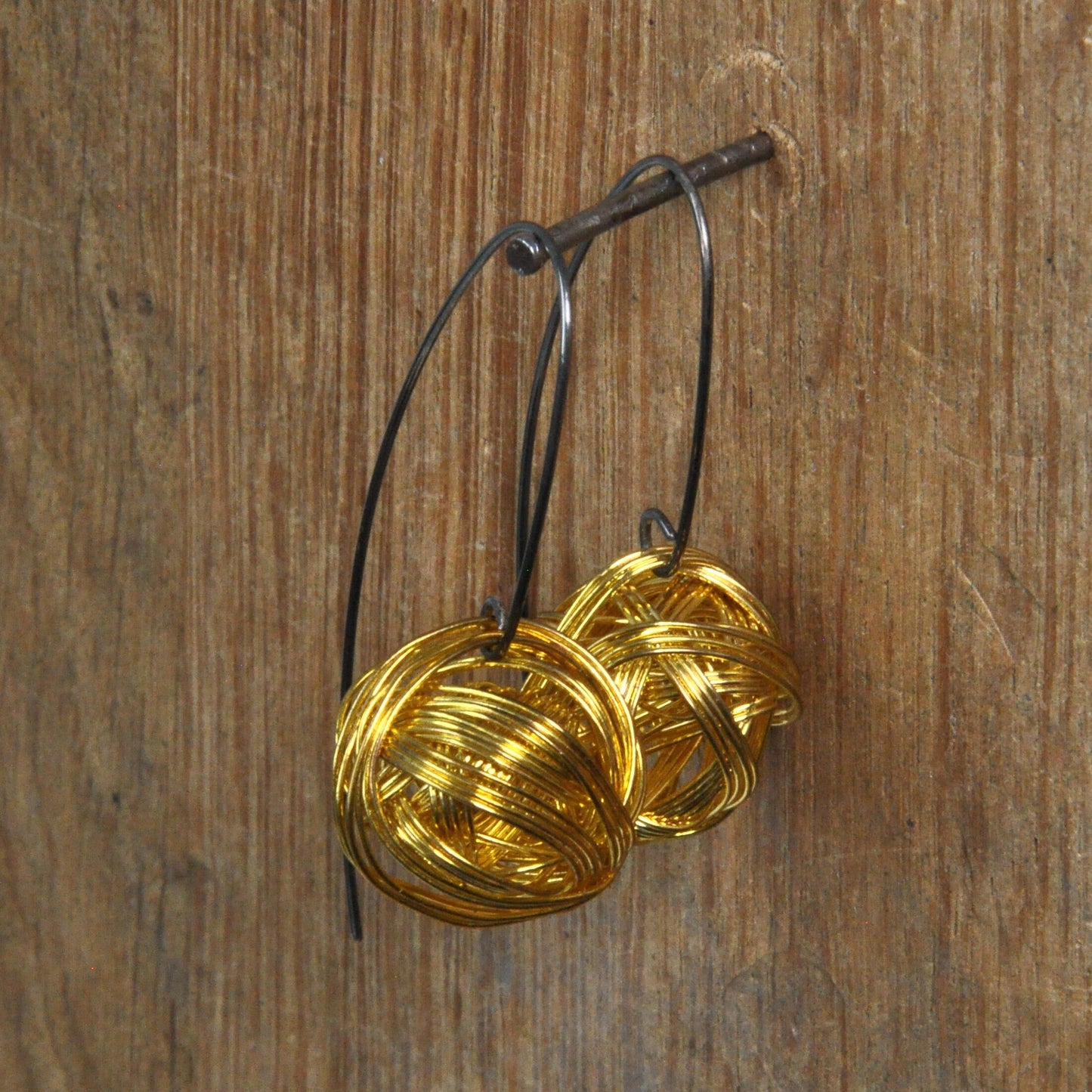 Geometric dangling earrings of brass and silver 'Golden Motes'